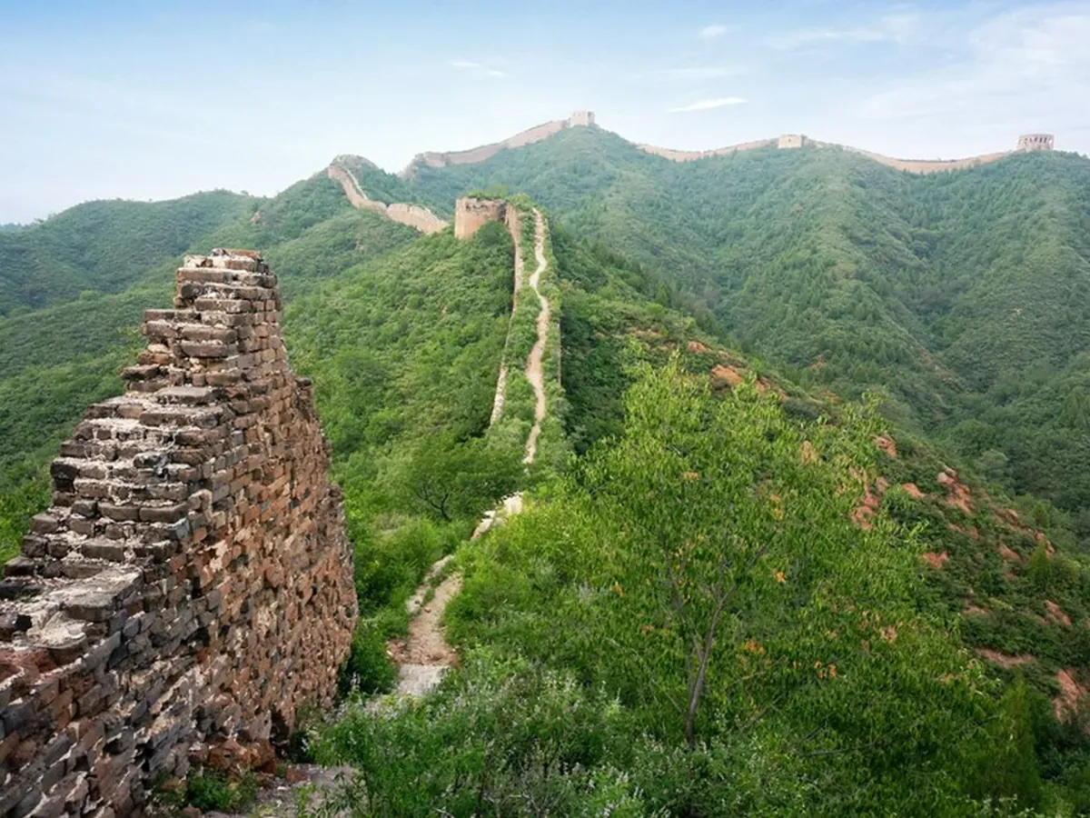 Unrestored Ming brickwork at Gubeikou with the restored wall climbing the ridge beyond