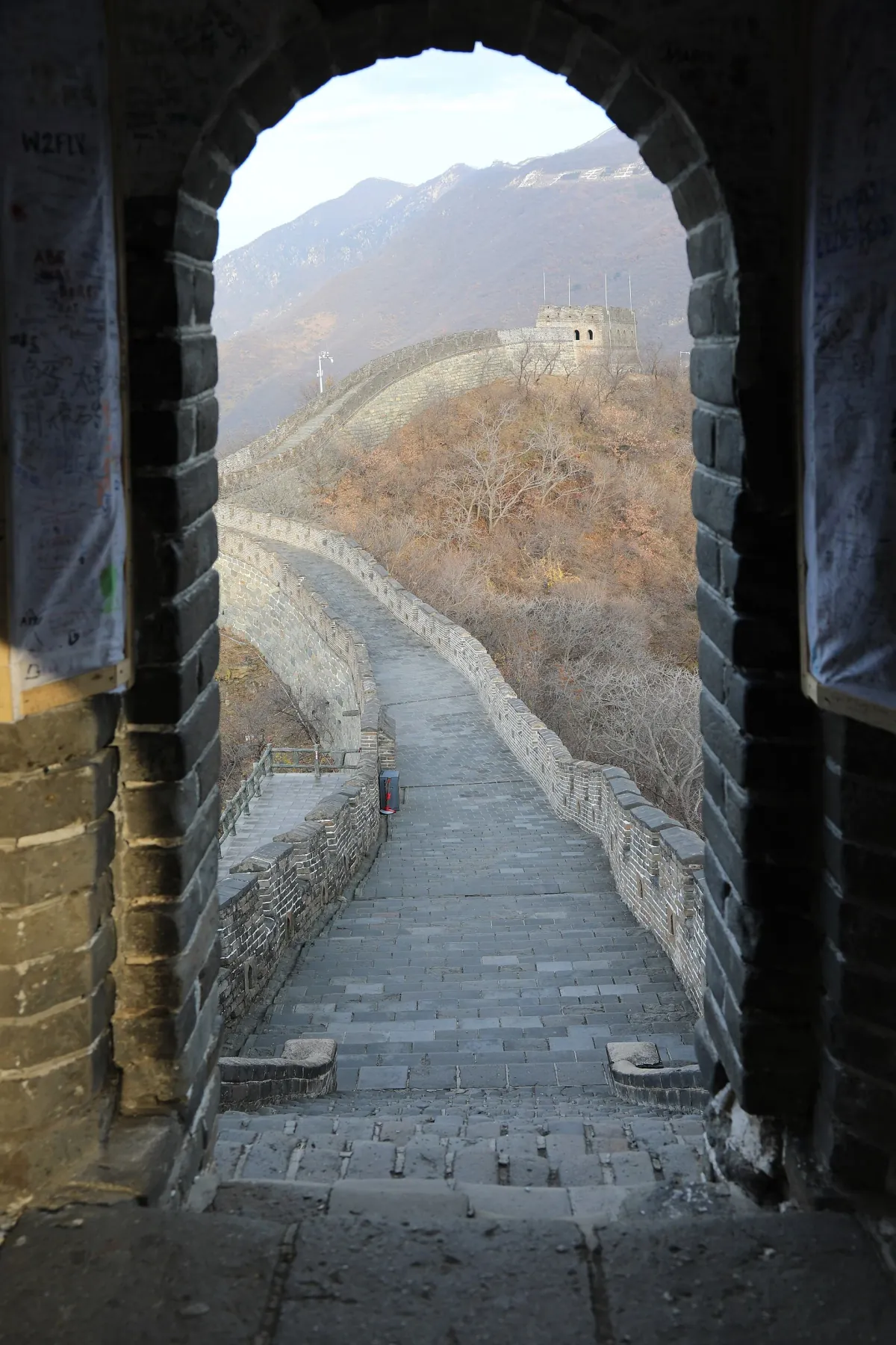 Cold-season light on bare hillsides: steps through a Mutianyu watchtower arch (photo: Mutianyu)