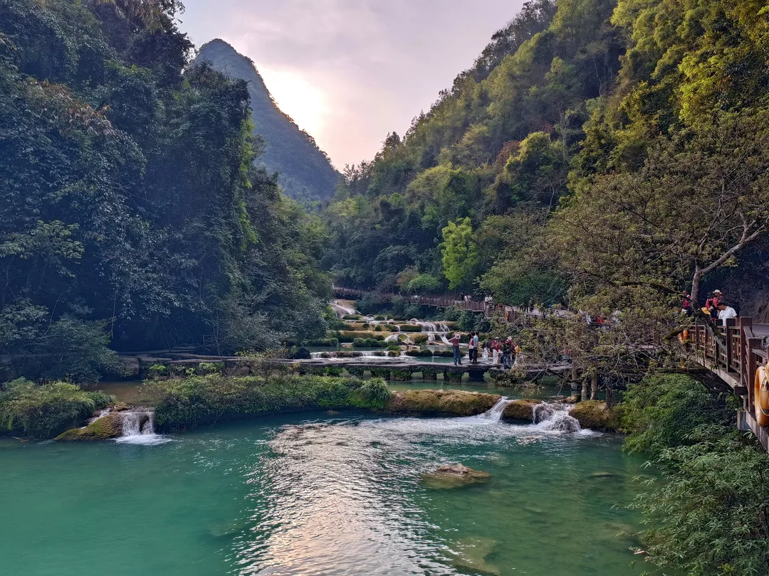 Turquoise water and travertine cascades in the karst gorge of Xiaoqikong