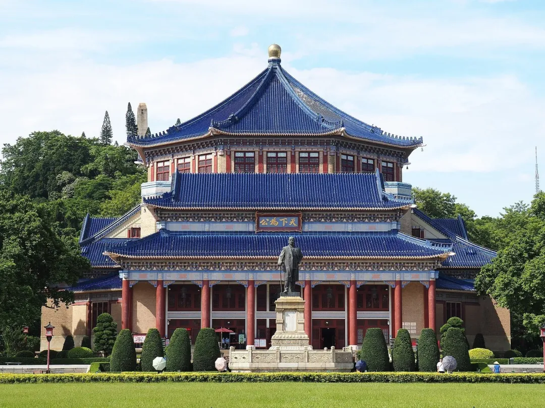 The Sun Yat-sen Memorial Hall's blue octagonal roof and statue above a manicured lawn in Guangzhou