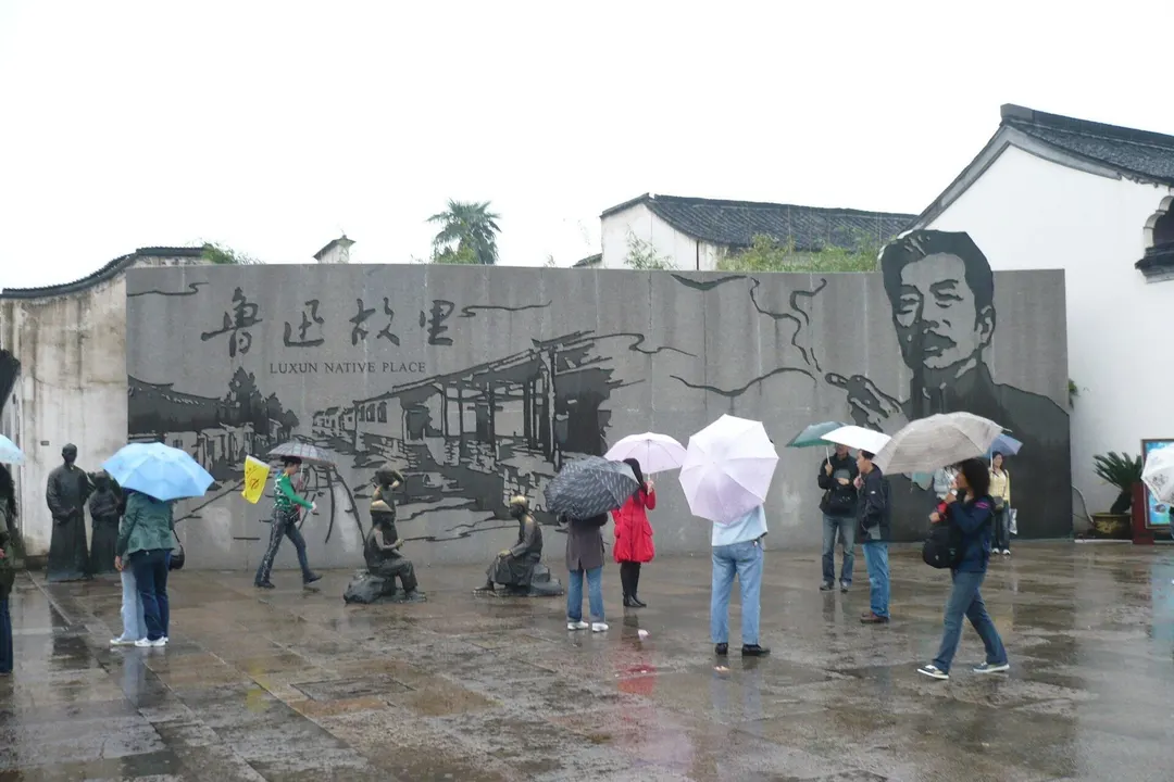 Granite mural wall at Luxun Native Place with carved canal scene, portrait of Lu Xun and bronze street figures