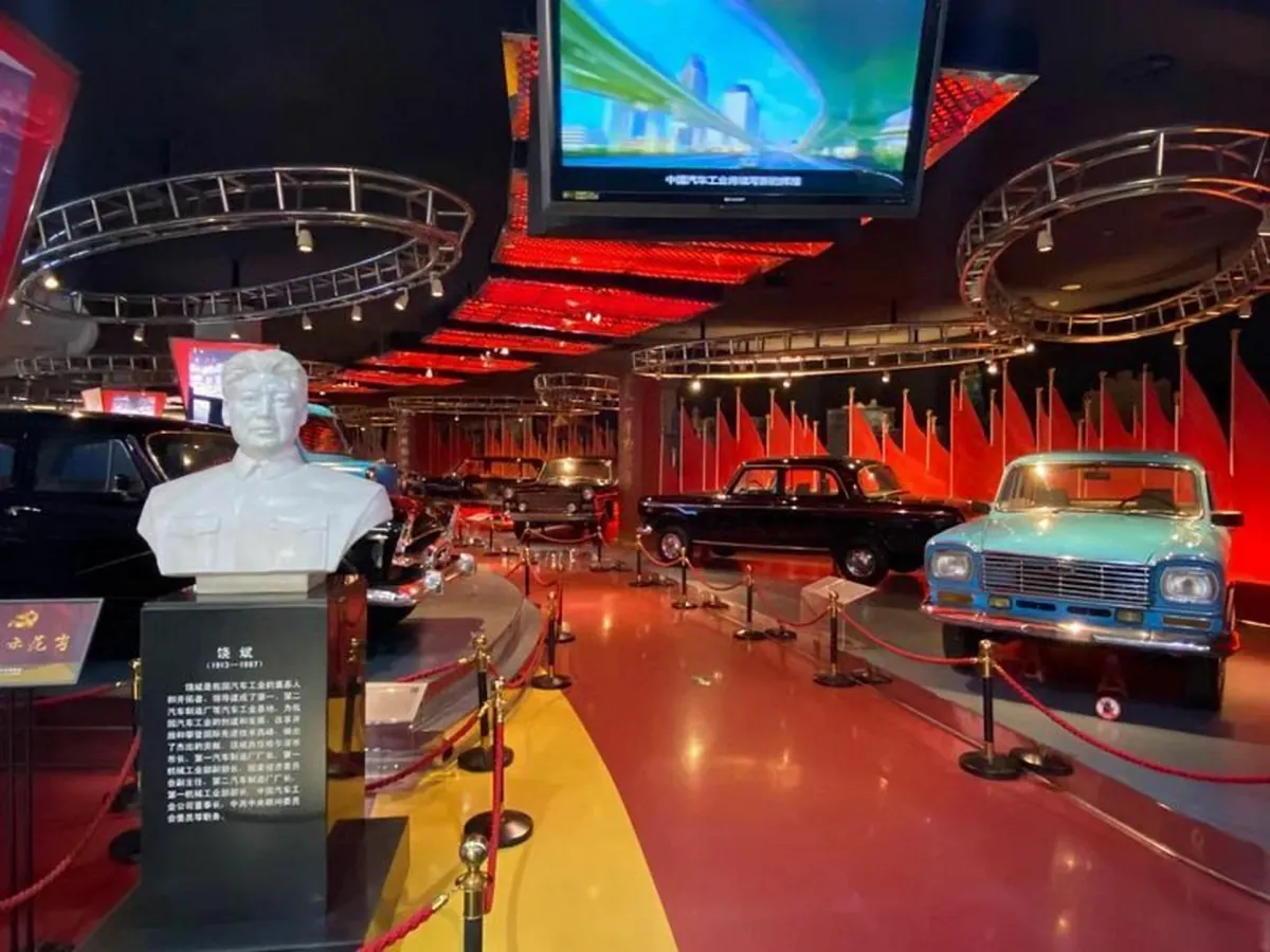 北京汽车博物馆展厅内景,人物半身雕像与红旗、上海牌经典轿车展品