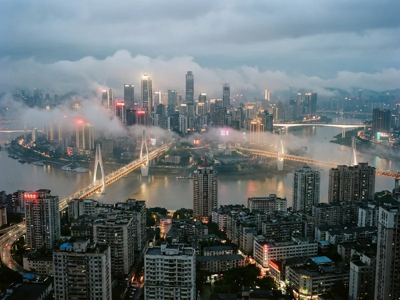 Hongya Cave stilted buildings in Chongqing lit up at night above the confluence of the Yangtze and Jialing rivers