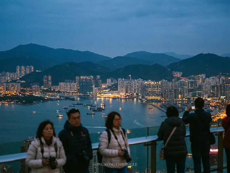 Hong Kong Island skyline at dusk viewed from Victoria Peak, with Victoria Harbour in the foreground